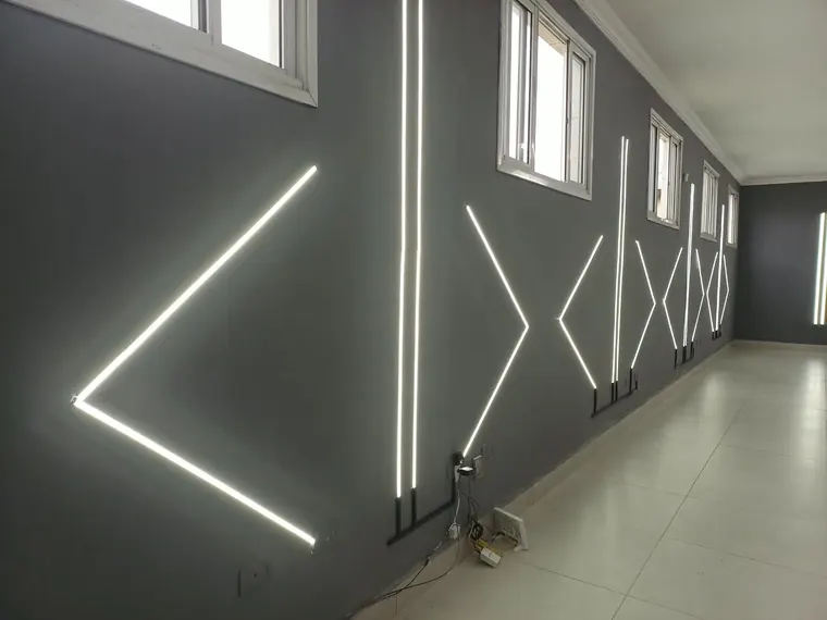 Corredor com arte em perfil de LED na parede.