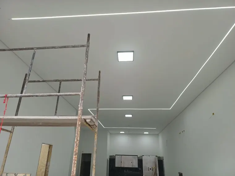 Forro com perfis de LED e plafons embutidos.