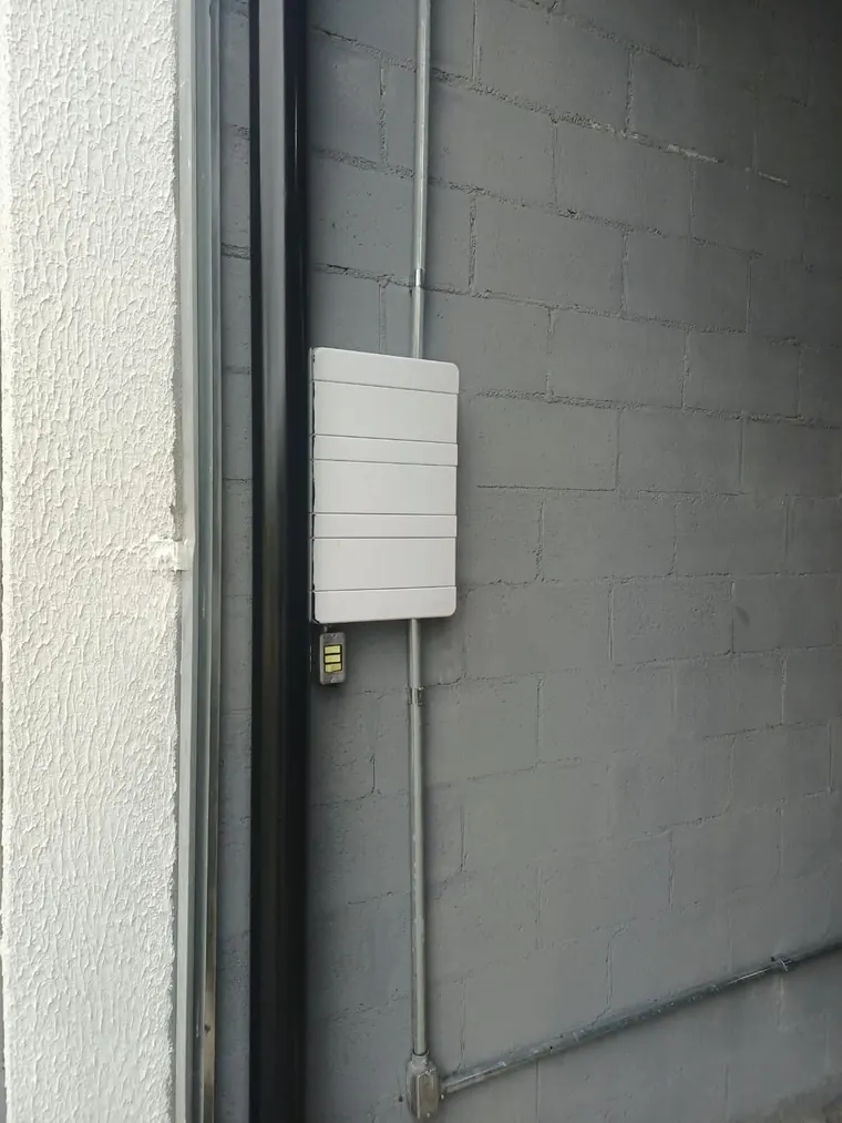 Instalação aparente com eletroduto galvanizado e quadro de sobrepor em parede de bloco.