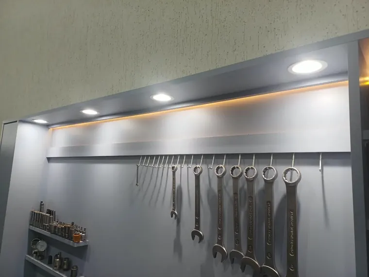 Parede de ferramentas de oficina iluminada com spots embutidos e fita de LED.