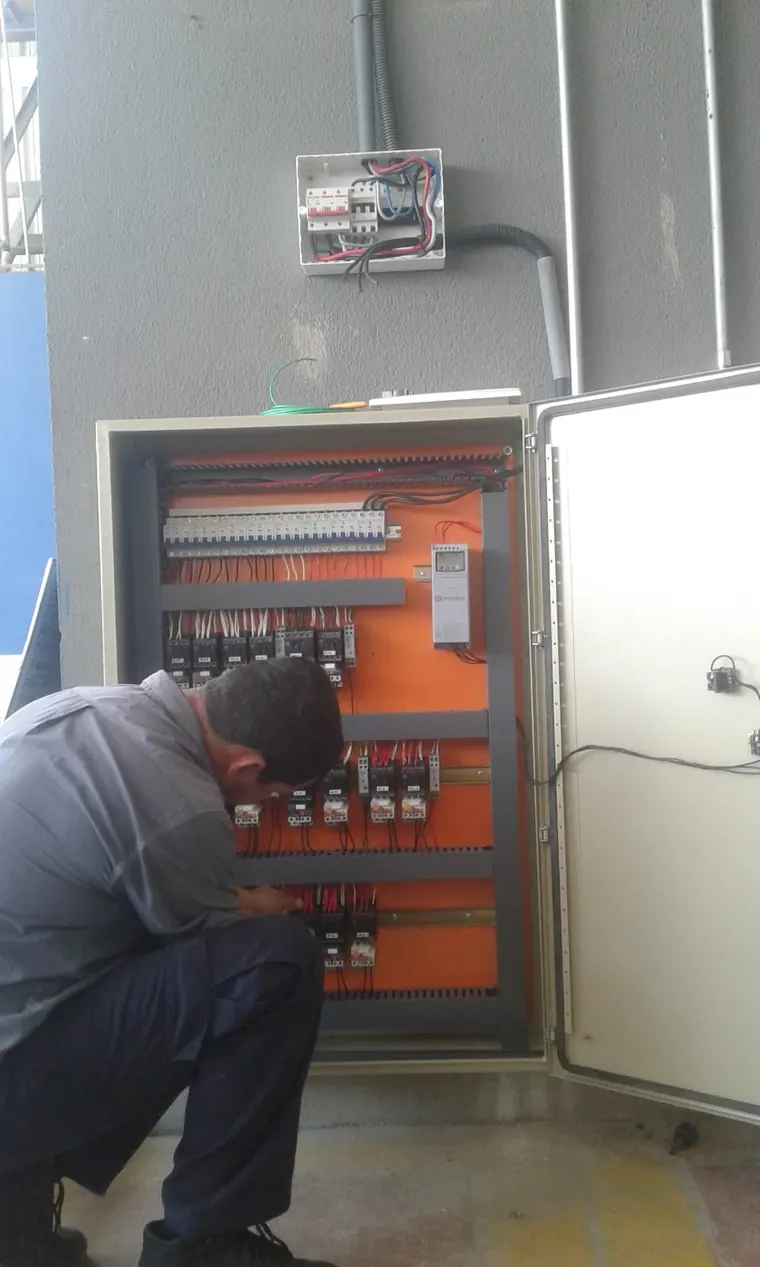 Eletricista da JM montando um quadro de comando industrial.